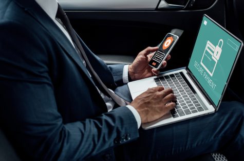 cropped-view-of-african-american-businessman-using-laptop-and-smartphone-in-car-with-cyber-security.jpg